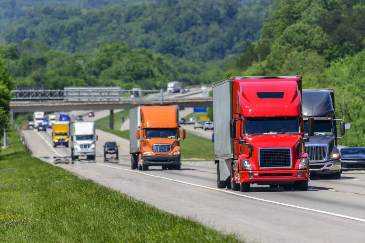Large semi trucks driving on the interstate to deliver truckload freight